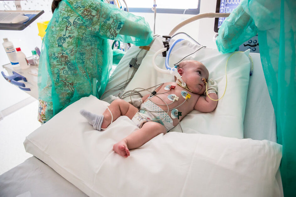 Infermeres acomoden la posició del llit a un nadó a qui fan un electrocardiograma (ECG) a la Unitat de Cures Intensives Pediàtriques (UCIP)